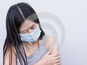 Vaccination, immunization disease prevention concept Woman in mask receives COVID-19 vaccine or the flu makes a painful face