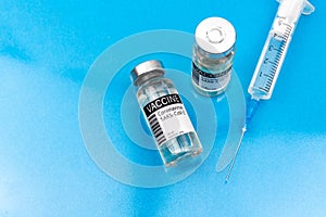 Vaccination preparation concept background with coronavirus covid vaccines and medical syringe, glass table