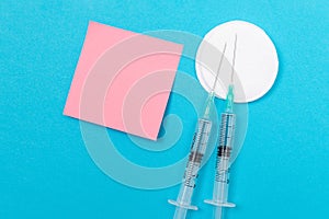 Vaccination or Revaccination Concept - Two Medical Syringe on Blue Table