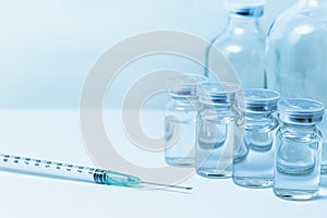 Vaccine bottle with syringe injection medical needle with space for text blue color tone
