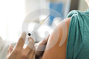 Vaccine or flu shot in injection needle. Doctor working with patient`s arma.