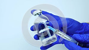 Vaccine Syringe with a can for coronavirus infection,a doctor demonstrates a cure for covid-19,close-up. Medical remedy for the vi