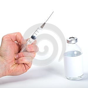 Vaccine in syringe. Start of vaccination. Hand with syringe on white