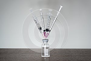 A vaccine vial with 4 syringes. photo