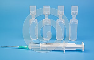 Vaccine vials and a syringe with blue background medicine vaccination concept. photo