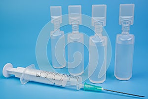 Vaccine vials and a syringe with blue background medicine vaccination concept. photo