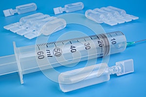 Vaccine vials and a syringe with blue background medicine vaccination concept. photo