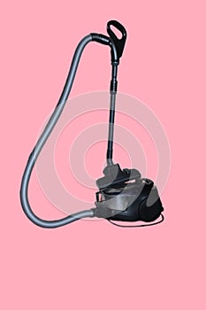 Vacuum cleaner of black colour with hose of silver colour