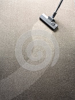 Vacuum cleaner on a carpet with a clean strip for copy space