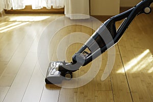 Vacuum cleaner cleaning bamboo flooring in a room