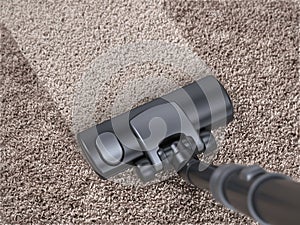 Vacuum cleaner cleans dirty carpet - house cleaning concept photo