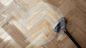 Vacuum cleaner nozzle on herringbone parquet flooring. Home cleaning in progress. Concept of housekeeping, wooden floor