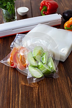 A vacuum cleaner with a pack of vacuum bags and green apples and peppers packed