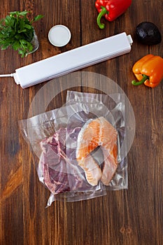 Vacuum cleaner with vacuum bags with a piece of beef and salmon with vegetables