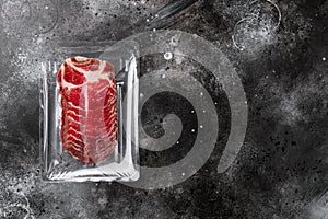 Vacuum packed cured coppa ham , on black dark stone table background, top view flat lay, with copy space for text