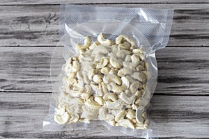 Vacuum-packed dried cashews on a wooden background. Plant-based diet, healthy fats, keto diet, lchf photo