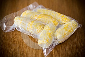 Vacuum-packed fresh corn on a wooden table