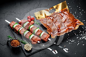 Vacuum-packed grilled meat, on a dark background.