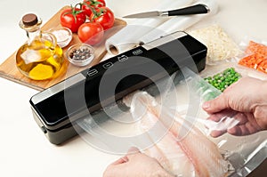 Vacuum packing machine. For long-term storage of food. Male hands are packing the fish. Top view light background