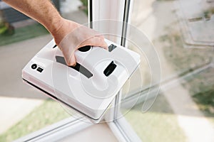 Vacuum robot for cleaner windows in men`s hands. Stylish automatic glass and window cleaner.