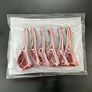 Vacuum-sealed lamb chops on black surface for freshness and quality