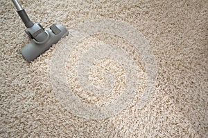 Vacuuming rough carpet with vacuum cleaner photo
