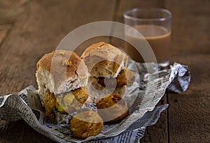 Vada pav with a glass of tea, very famous street food of india, specially in the state of Maharashtra, selective focus