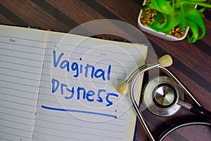 Vaginal Dryness write on a book isolated on Wooden Table