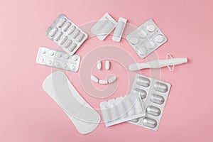 Vaginal suppositories, tablets, applicator and sanitary napkin on pink background