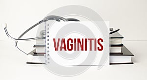 Vaginitis word on notepad and stethoscope on white background