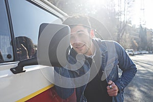 Vain man checking his looks in the mirror of his car