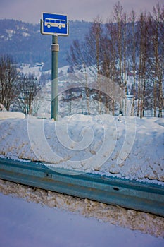 Valdres, Norway - March 26, 2018: Outdoor view of sign of bus stop at one side during winter in the road