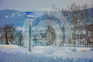 Valdres, Norway - March 26, 2018: Outdoor view of sign of bus stop at one side during winter in the road, with snow and