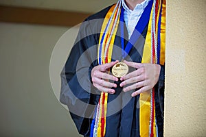 Valedictorian Shows off Medal with Graduation Gown photo