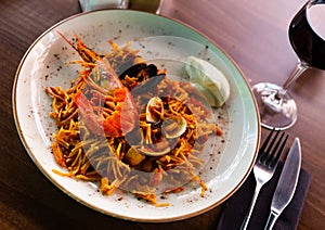 Valencian seafood fideua served on plate with sauce allioli photo