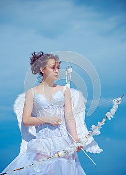 Valentin angel teen girl in white angels dress with wings. Valentines teenager girl with bow arrow.