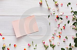 Valentine background with scattered pink rose flowers and petals on white rustic wood