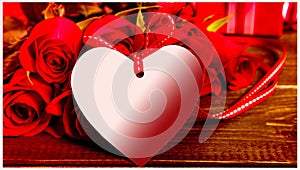 Valentine background of white gift tag and red roses on wood. Space for copy. Valentine's day. 14 th february. Heart on a flower