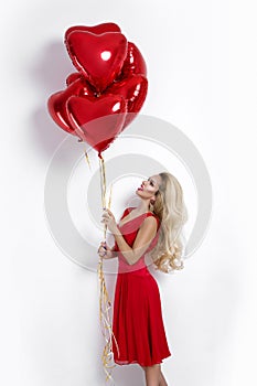 Valentine Beauty girl with red air balloon isolated on white background. Beautiful Happy Young woman presenting products.