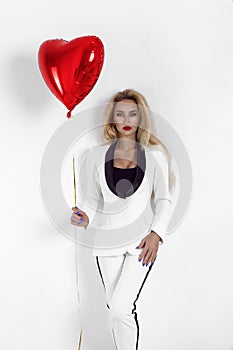 Valentine Beauty girl with red air balloon portrait, isolated on background. Beautiful Happy Young woman in an elegant tuxedo.