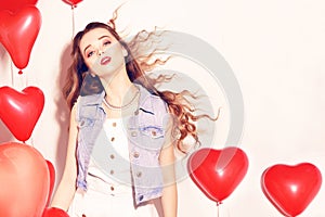 Valentine Beauty girl with red air balloons laughing, on white background. Beautiful Happy Young woman. Womans day. Holiday party.