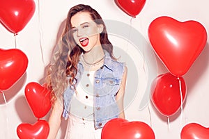 Valentine Beauty girl with red air balloons laughing, on white background. Beautiful Happy Young woman. Womans day. Holiday party.