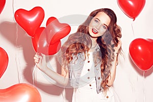 Valentine Beauty girl with red air balloons laughing, on white background. Beautiful Happy Young woman. Womans day. Holiday party.