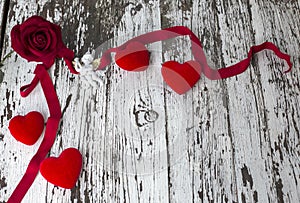 Valentine card with rose, white angel and red heart shapes on wooden board, copy space. Top view, flat lay