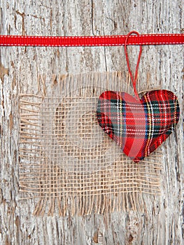 Valentine card with textile heart and sacking on old wood