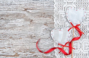 Valentine card with textile hearts on lacy cloth and old wood