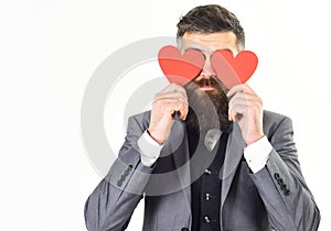 Valentine cards. Hipster with long beard holds red hearts, valentine cards