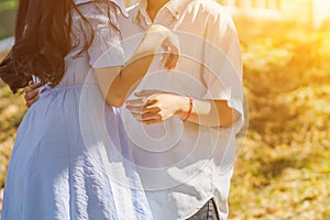 Valentine couples are talking and standing holding hands on a blurred background in the morning to promise to look after each