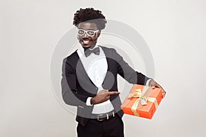 Valentine day. African businessman pointing fingers at gift box