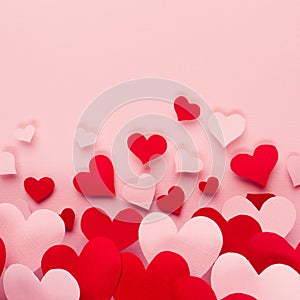 Valentine day background of fly paper red and pink hearts on pink color backdrop. Copy space.